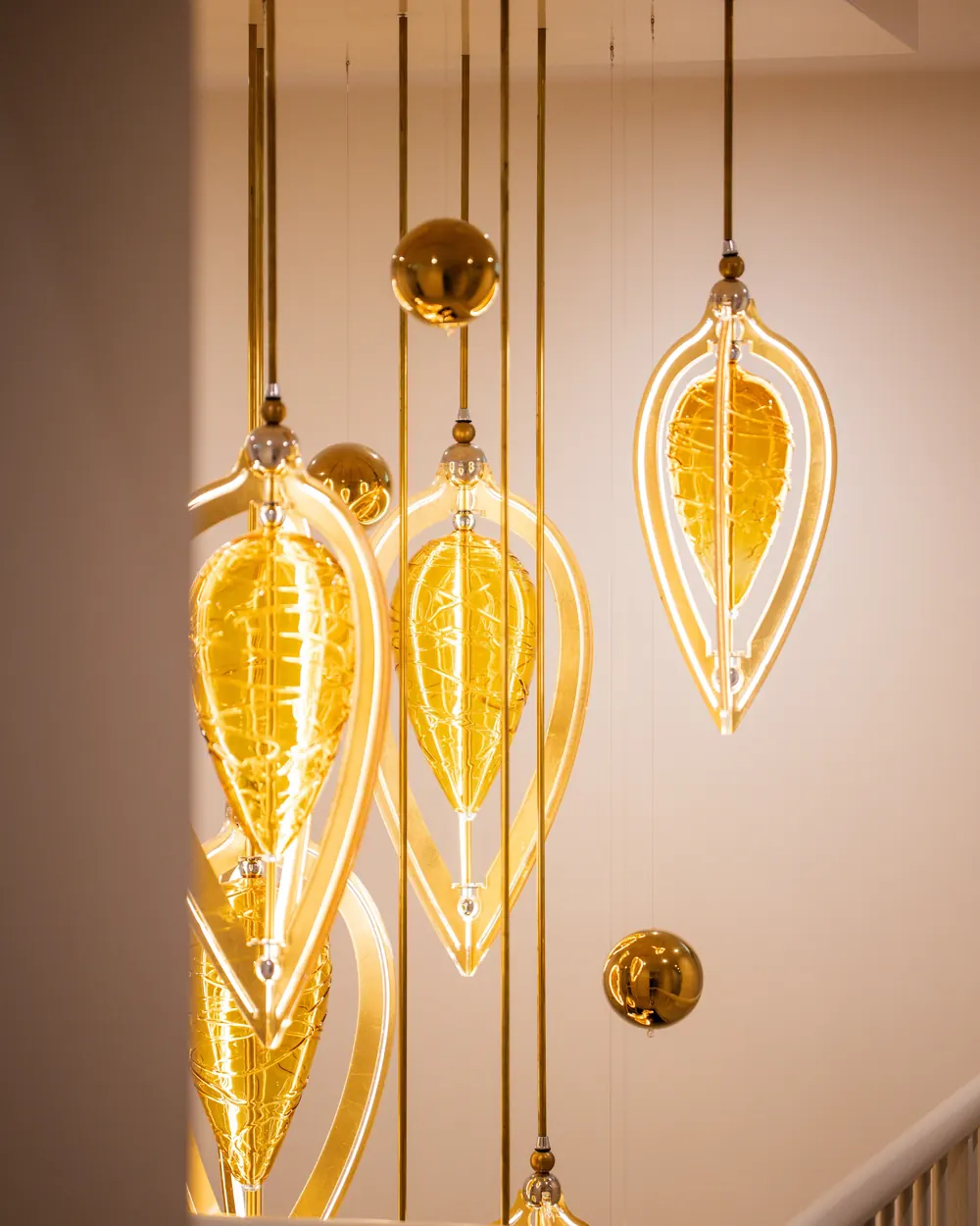 The golden pendant lights above the staircase
